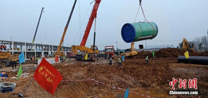  1月29日晚，武汉蔡甸火神山医院最大雨水处理一体化泵站完成吊装，标志着该应急医院排水“主动脉”就位。中新社发 谢定军 摄