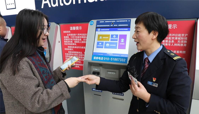 北京南站售票车间副主任董芳帮助旅客打印报销凭证。中国网记者 刘维佳／摄