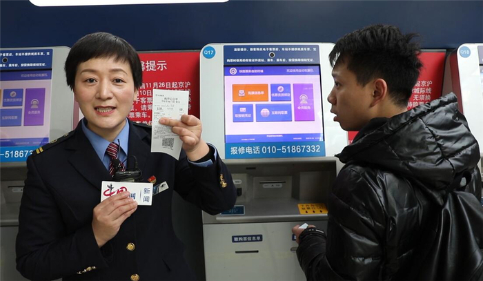 北京南站售票车间副主任董芳帮助旅客打印信息凭条。中国网记者 刘维佳／摄