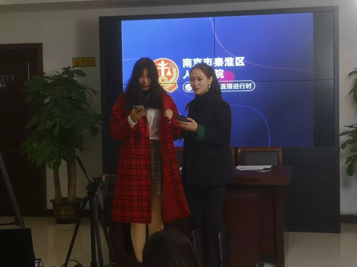 2019年12月21日，南京秦淮法院，法院的工作人员正在试穿拍卖的红色外套。