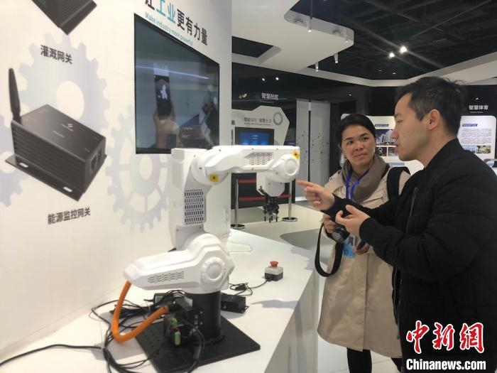 工作人员为采访团成员介绍物联网赋能工业制造。　孙权 摄