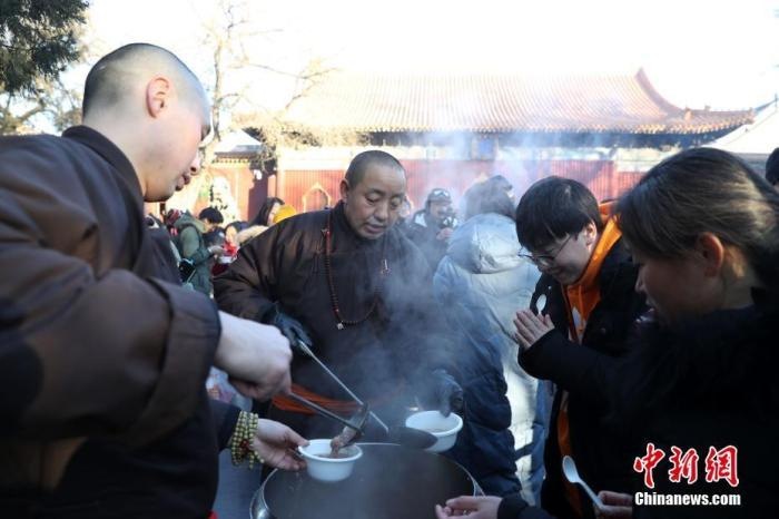 资料图：在北京雍和宫舍粥点前，人们排起百米长队等待领取腊八粥（中新社记者 韩海丹 摄）