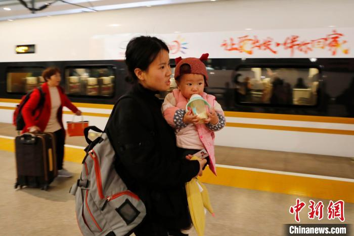 旅客带着孩子乘坐长三角铁路首趟春运团体包车回家。　殷立勤 摄