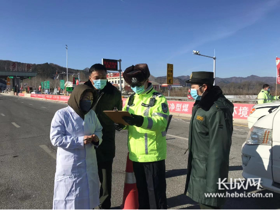 工作人员正在高速路口进行车辆登记。姜景文摄