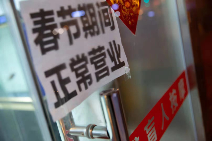 门口贴着“春节期间 正常营业”的盲人按摩店。新京报记者 李凯祥 摄