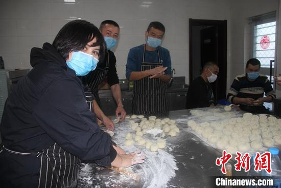 尼加提•外力和妻子古扎丽努尔•克音木和同事包饺子。　邱琳涵 摄