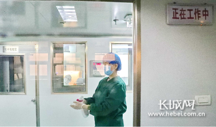 秦皇岛市疾控中心检验科检验人员完成实验消毒出污染区。曹建雄 摄