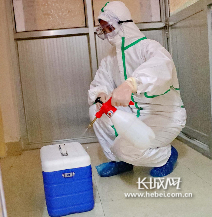 秦皇岛市疾控中心检验科检验人员给标本箱消毒。曹建雄 摄