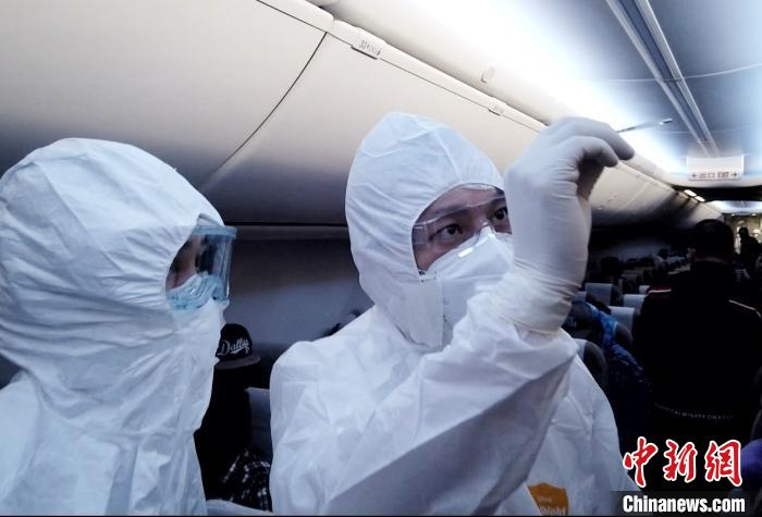     安全员配合随机医生对旅客进行水银体温计测体温　东航供图　