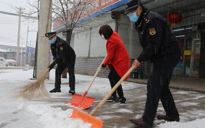 山东庄镇下沉一线的城管执法队员主动协助扫雪铲冰工作。受访者供图
