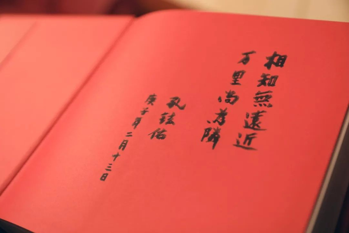  2月13日，中国驻日本大使孔铉佑向旗袍女孩赠送《中国世界遗产影像志》上的题字。新华社记者 杜潇逸 摄