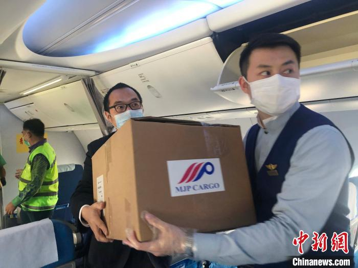 图为机组人员往客舱装货物。　钟欣 摄