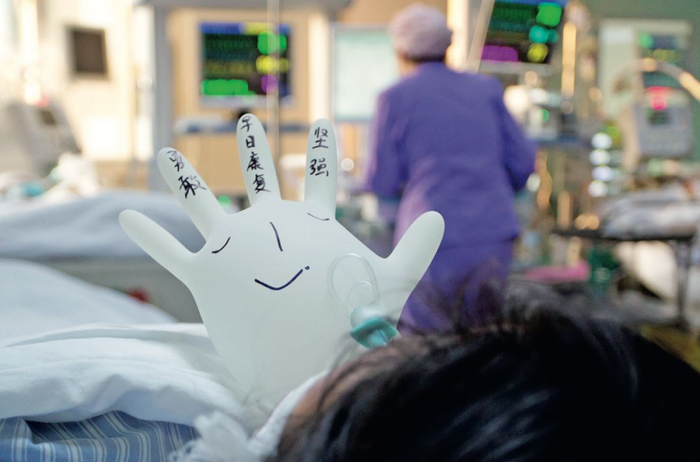 ICU病房内，医护人员将手套吹成气球的形状，写上一些鼓励的话，为病人加油鼓气，给病房增加了一些生气。图/ 视觉中国