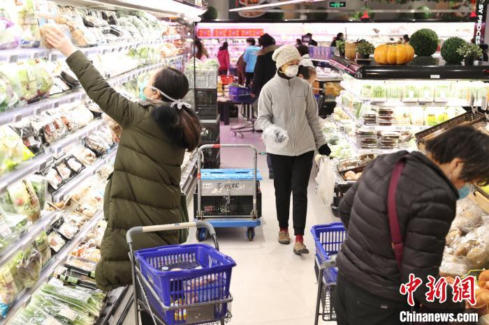 超市内，市民戴口罩选购商品。　张亨伟 摄