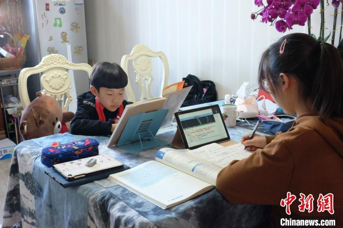 银川二中高一学生边古玥与弟弟一同通过云平台学习新课内容。 受访者供图