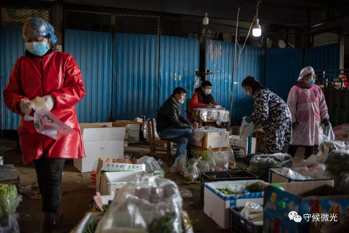  2月17日，湖北省孝感市沙沟果蔬批发市场内，老板李智（左三）和家里来帮忙的亲戚在整理清算要配送的蔬菜。自正月初五以来，他们直接与社区街道对接，为4个小区定点配送，每天配送量约有三千斤。据李智介绍，他和同行经常接到市民电话，反映自己的小区无法获得蔬菜配送资源，因为是封闭管理又无法外出买菜，希望得到帮助。中青报·中青网记者 李隽辉/摄
