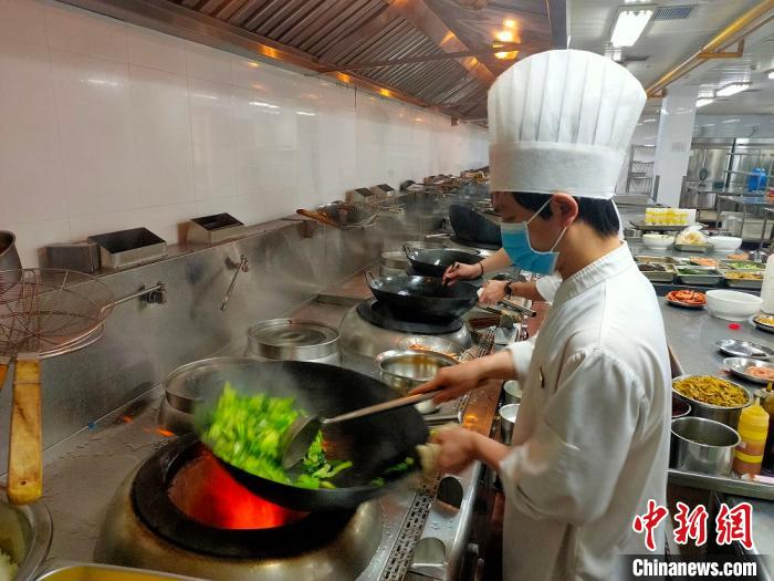 百年老店内厨师掌勺外卖餐食。　咸亨酒店供图 