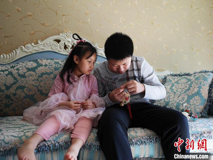     李昕达帮妹妹修玩具　苍雁　摄