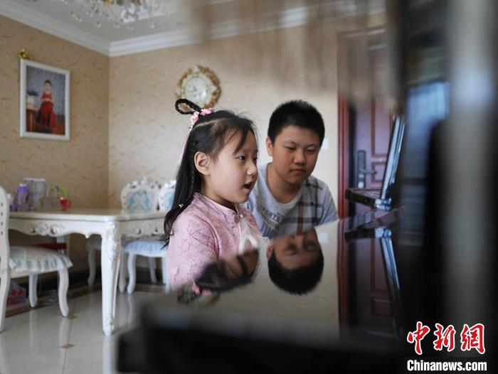 哥哥会监督妹妹练琴 苍雁 摄