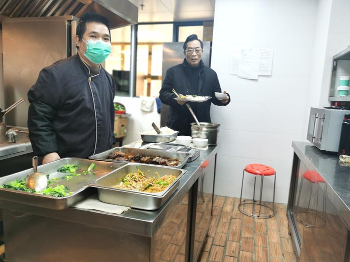 酒店大厨（左）而今给员工烧菜。（李晔 摄）