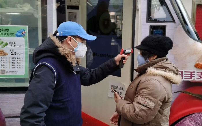 ▲2月19日，工作人员在为使用AI移动菜场的居民测体温。受访者供图