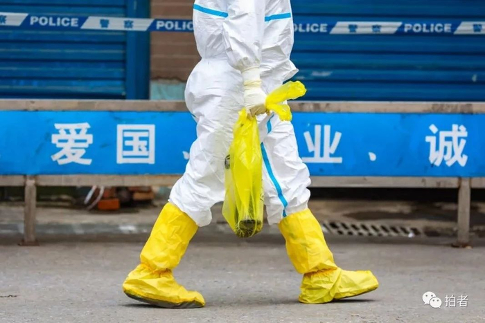  △&nbsp;华南海鲜市场商户门前，工作人员拎着一只大鲵（娃娃鱼）。摄影/长江日报记者陈卓