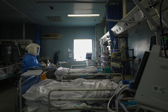  2月13日，武汉金银潭医院，医务人员在ICU内查看患者身体状况。长江日报 陈卓摄