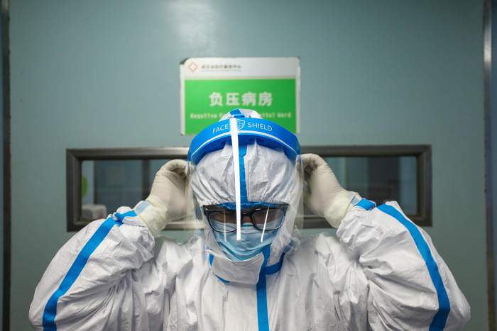  2月13日，武汉金银潭医院，一位医生在进入负压病房前穿戴防护装备。长江日报 陈卓摄