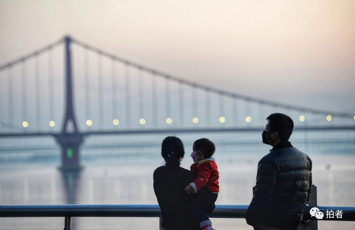  △&nbsp;武昌江滩，落日余晖下，戴口罩的一家三口。摄影/成都商报·红星新闻记者王效