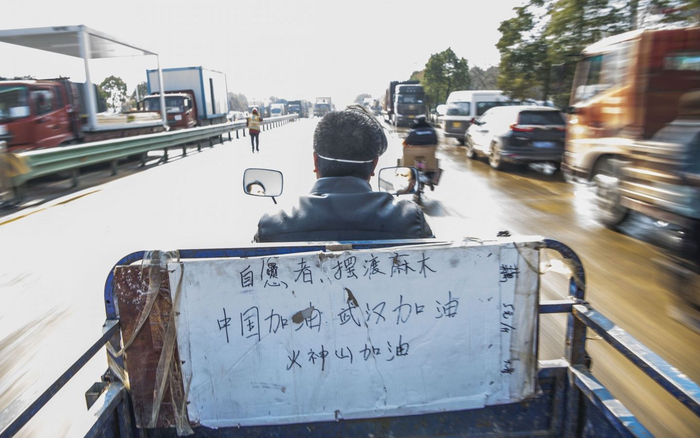  一位市民成为火神山医院工地的摆渡志愿者，一天在工地和停车点间往返百余次，送建设工人回驻地。摄影/ 新京报记者 陶冉