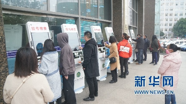  2月24日，人们在贵州省人民医院门诊大楼外的自助机前挂号、缴费。新华网发