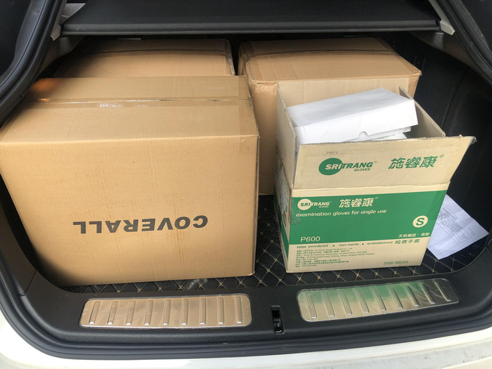 后备箱装满防护服和护目镜，准备送往医院。