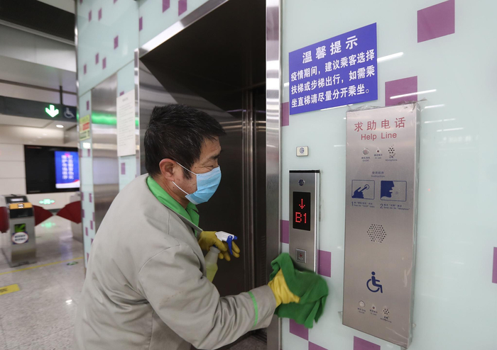 保洁人员对地铁站直梯按钮进行消毒。新京报记者 王贵彬 摄