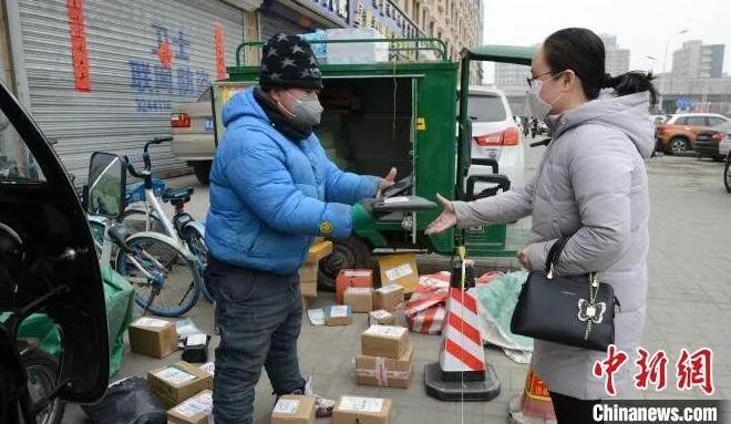 图为快递工作人员在小区口围起来一小片区域，收发快递。　刘文华 摄