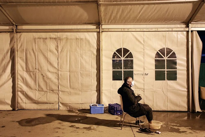 　　2月18日，武汉客厅方舱医院的洗漱间风雨棚里，一位被隔离的轻症患者正在泡脚。摄影/长江日报 陈卓