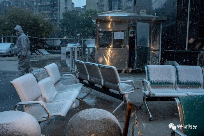 　　2月15日，湖北省武汉市武昌区，湖北大中中医院门前，一名工作人员经过。椅子上已经落了厚厚一层雪。中国青年报&nbsp;李隽辉/摄