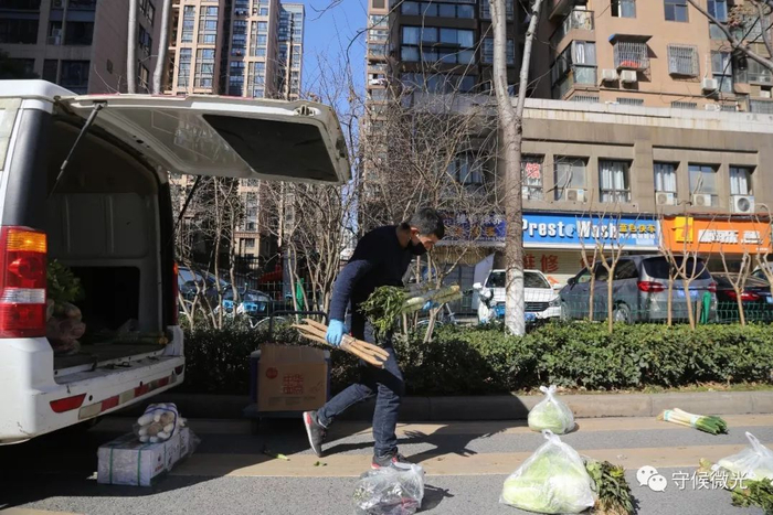 2月16日，湖北省武汉市，送菜小哥许可在为取单的小区居民摆放货品。中国青年报 赵迪/摄