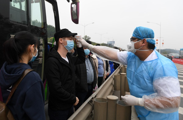 2月1日，在南宁东高速公路收费站附近，工作人员为进城大巴上的乘客测量体温。 新华社记者 陆波岸 摄
