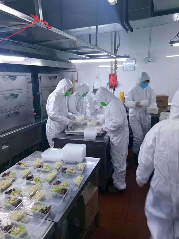  餐饮部门工作人员身着防护服为医护们准备餐食