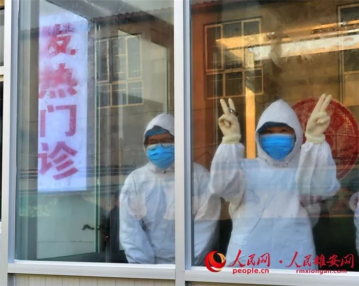 雄县人民医院发热门诊工作人员给群众也给自己打气。刘向阳摄