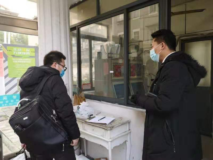 保安主管和返沪居民说明，要登记信息并申报给居委。&nbsp; 本文图片均为澎湃新闻见习记者 张慧 图