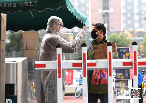 2月3日，洪山区关山街道保利花园小区防疫卫士对居民进行体温测量 长江日报记者高勇 摄