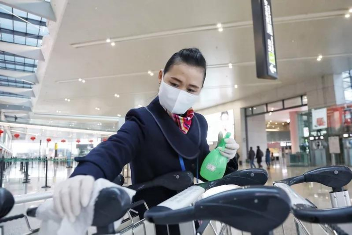 工作人员对手推车进行人工消毒