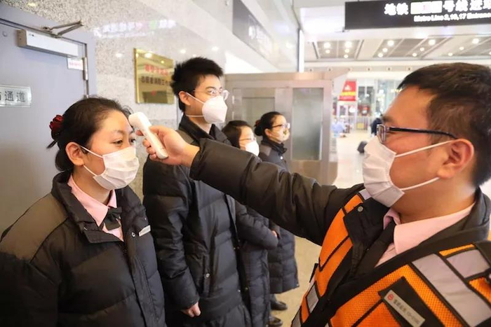 轨交虹桥火车站站值班站长张开凯为员工测温