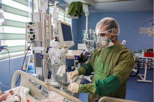 （图说：伊朗库姆佛尔卡尼医院，一名医生在治疗新冠肺炎患者。图/IFP/Mohsenzadeh）