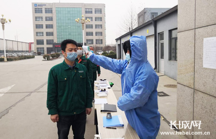 河北骄阳丝网设备有限责任公司门前，工作人员测量体温。张佳 供图