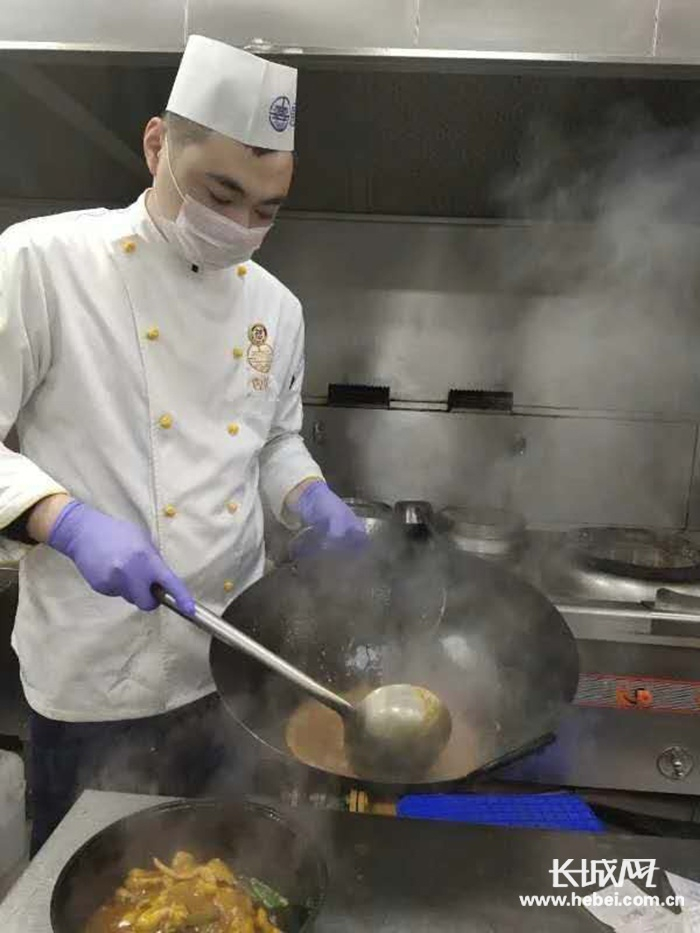 严格佩戴口罩、手套，保证菜品制作过程安全。唐山宴 供图