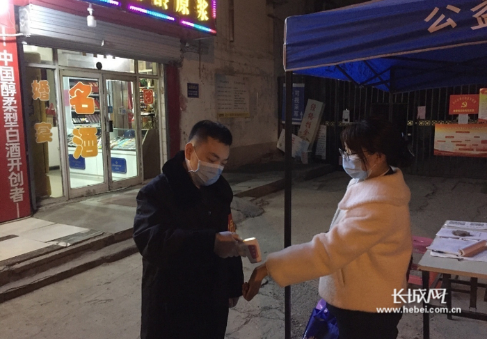 邯郸市丛台区人民检察院党员干部核查出入社区人员证件并测量体温。刘帅供图