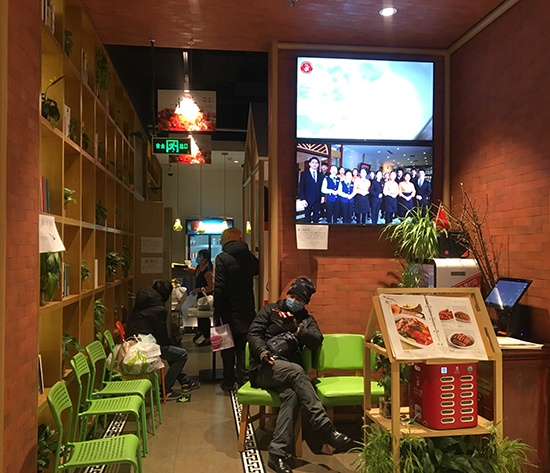 龙湖长楹天街在餐馆等取餐的外卖员