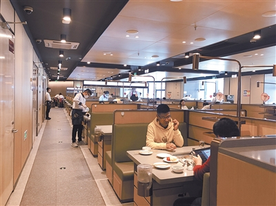 顾客在海底捞火锅隔桌用餐。陈晨摄